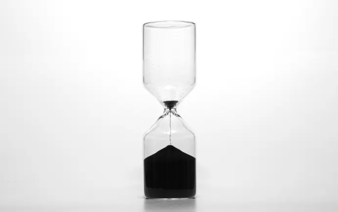 clear glass hour glass with black liquid